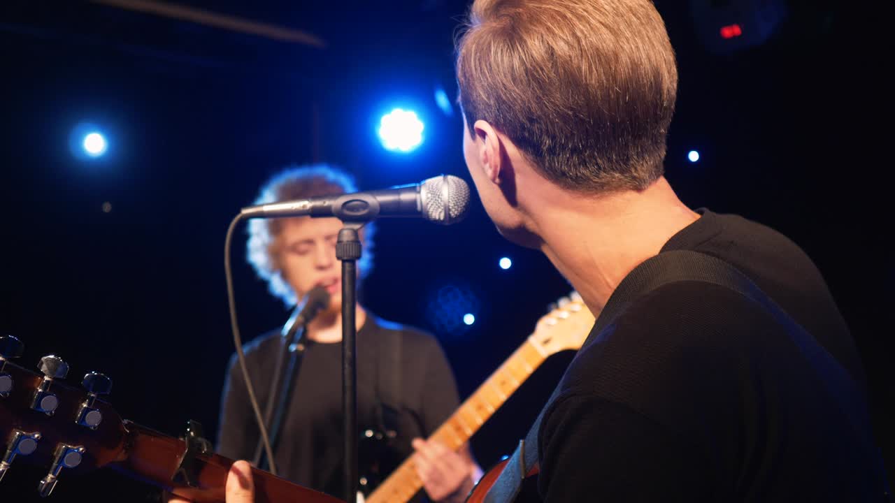 콘서트 록 밴드, 두 개의 전기 기타와 함께 무대에서 공연하는 가수, 뮤직비디오 크, 헤비 메탈 또는 록 그룹, 느린 동작 악기 연주 두 사람의 밴드