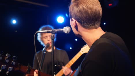 concert rock band performing on stage with two electric guitars singers. music video punk, heavy metal or rock group. slow motion instrument playing band of two men