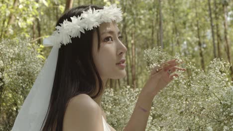 une superbe mariée asiatique pose dans un jardin fleuri pittoresque