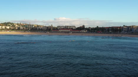 Drone-sliding-left-across-Bondi-Bay-on-a-Saturday-morning,-Sydney-Australia