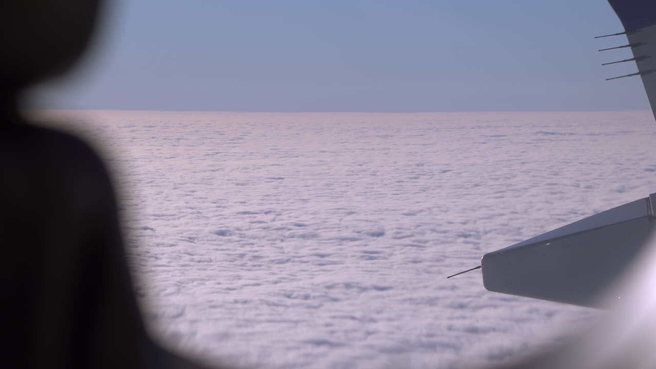View from an airplane window of the fluffy clouds