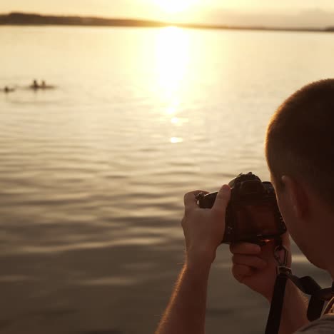 tourist is photographed on the beach of people swimming in the river at sunset