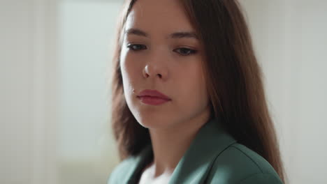 woman feels sorrows on light background closeup. thoughtful businesswoman suffers from harassment at workplace. office employee exhausted problems