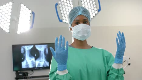 portrait of african american female surgeon wearing surgical gown and face mask, slow motion