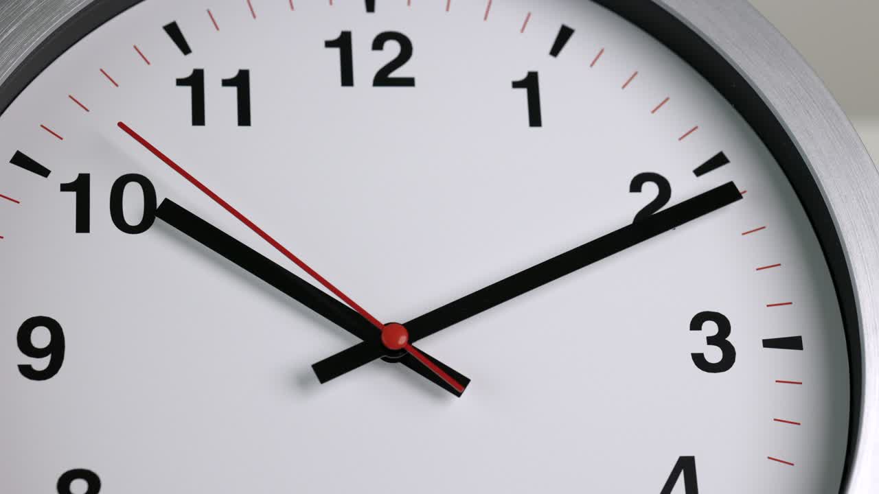 Grande orologio da parete bianco impostato sulle 10:10. La lancetta rossa dei minuti continua a girare. Filmato in time-lapse.