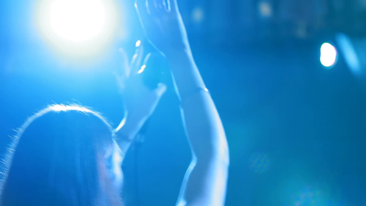 Female vocalist singing in dark stage during the concert