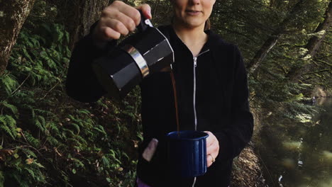 young woman pouring coffer in the forest