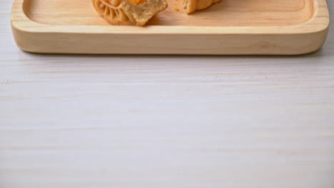 pastel de luna chino durian y sabor a yema de huevo con té en placa de madera