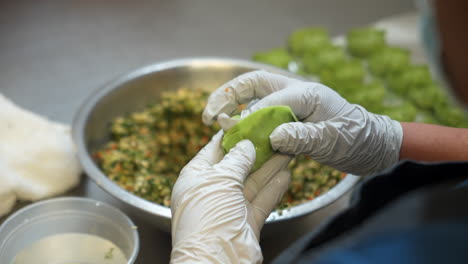 chef properly folds traditional chinese dumplings closed, hands prepare veggie dumplings, close up slow motion 4k