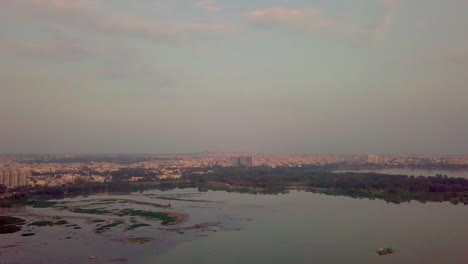 drone view capturing sunset over a lake in hyderabad, india with a beautiful cityscape.