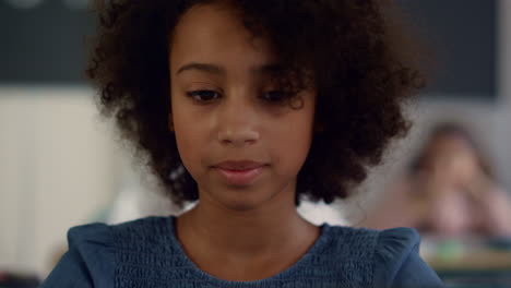 Girl-sitting-at-desk-in-classroom.-Pensive-student-learning-at-elementary-school