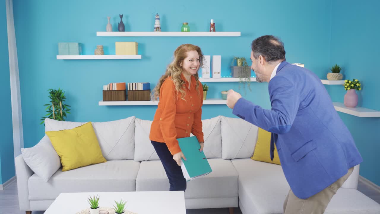 Husband and wife come home from work dancing.