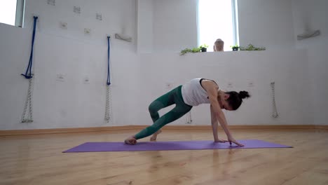 woman showing side lunge with arms extended pose in house