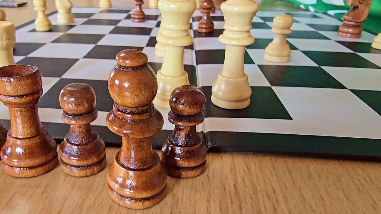 Close-up shot of hands moving wooden chess pieces during a game