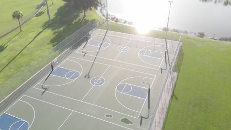 super smooth drone flight turning over 3 perfectly painted public blue basketball courts