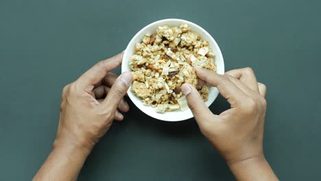 Müsli-Müsli-Von-Hand-Aus-Einer-Schüssel-Pflücken