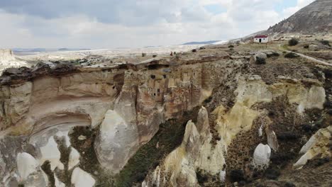 Un-Aire-Mavic-Avanza-Acercándose-A-La-Entrada-De-Una-Antigua-Casa-Escondida-En-Una-Roca-En-El-área-De-Zelve