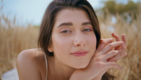 dreamy lady enjoying summer field laying spikelets closeup. young woman portrait