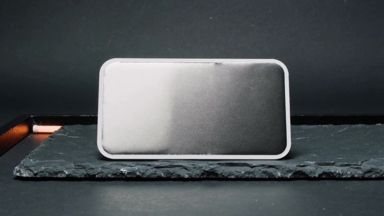 Sliding device with white bezel onto studio slate slab, prompted by orange light for showcase