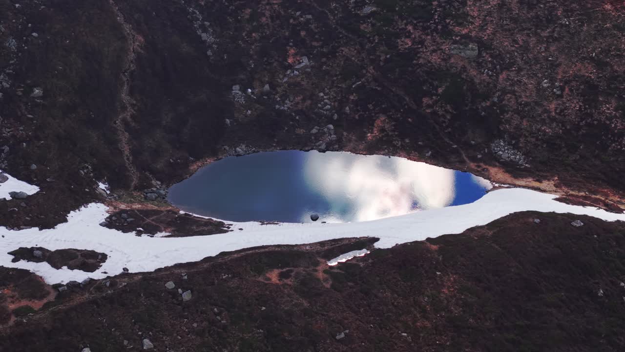 Snowy alpine lake with reflection, peaceful aerial view in the Dolomites Mountains