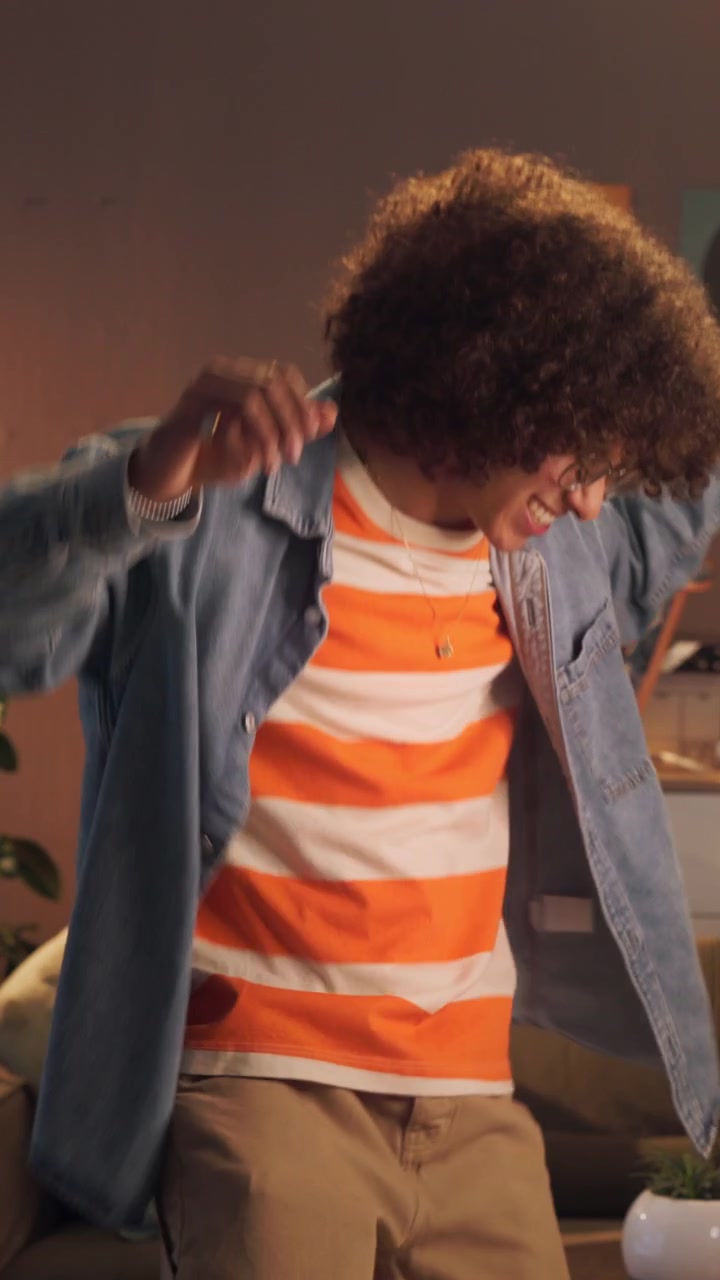 Young Man with Curly Hair Dancing Happily in Living Room