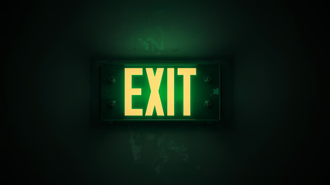 Powering rectangular EXIT sign emitting green halo on dark corridor wall, showing egress route