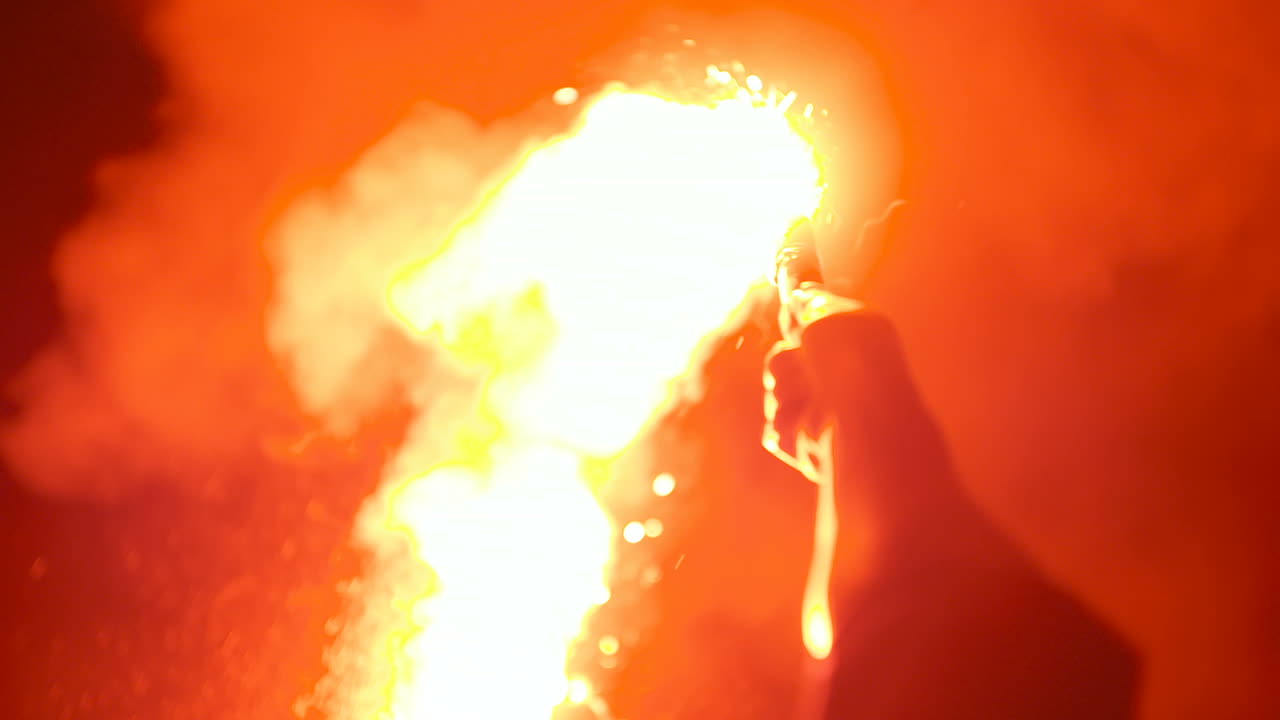 крупный план горящей сигнальной ракеты, которую держит мужчина 3