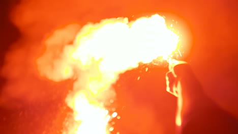 close up of a burning signal flare held by a man 3