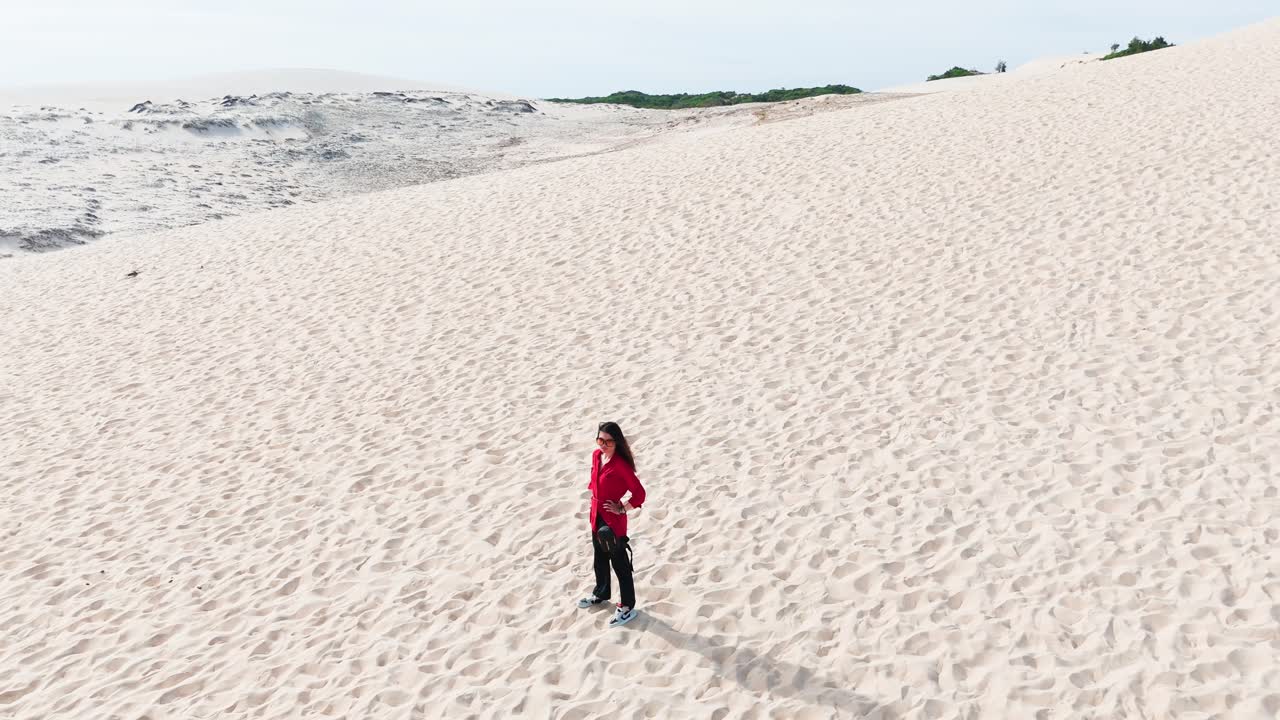 Aerial View of a Girl Standing and Walking on the Hill in the Desert.