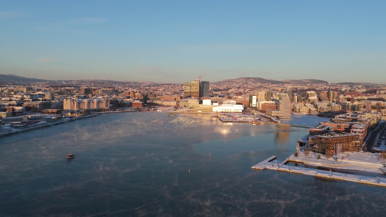vista de la hora de oro sobre bjorvika con la luz del sol reflejándose en el fondo de la ópera de oslo