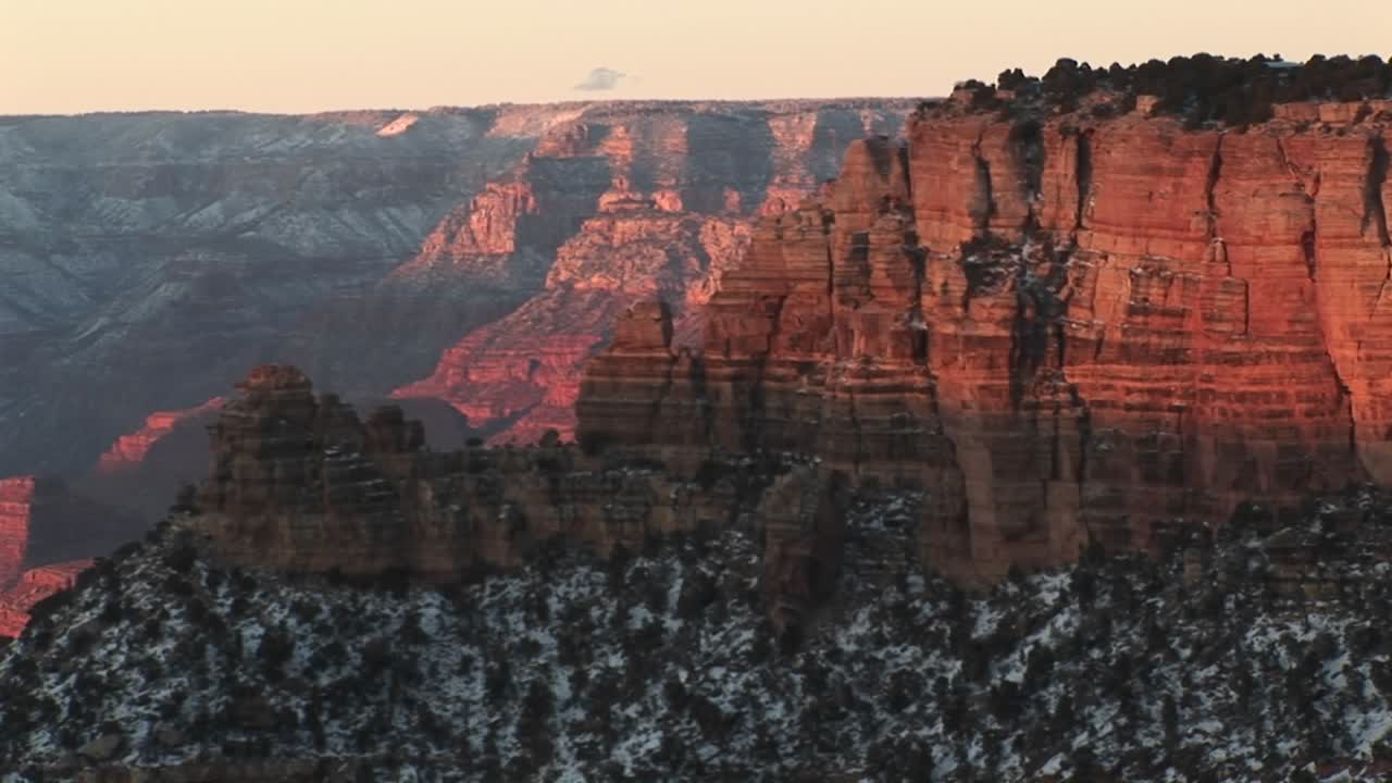 et bredt billede af grand canyon national park med de lagdelte klipper på den nordlige kant af kløftens væg, der svæver over vinterens sne