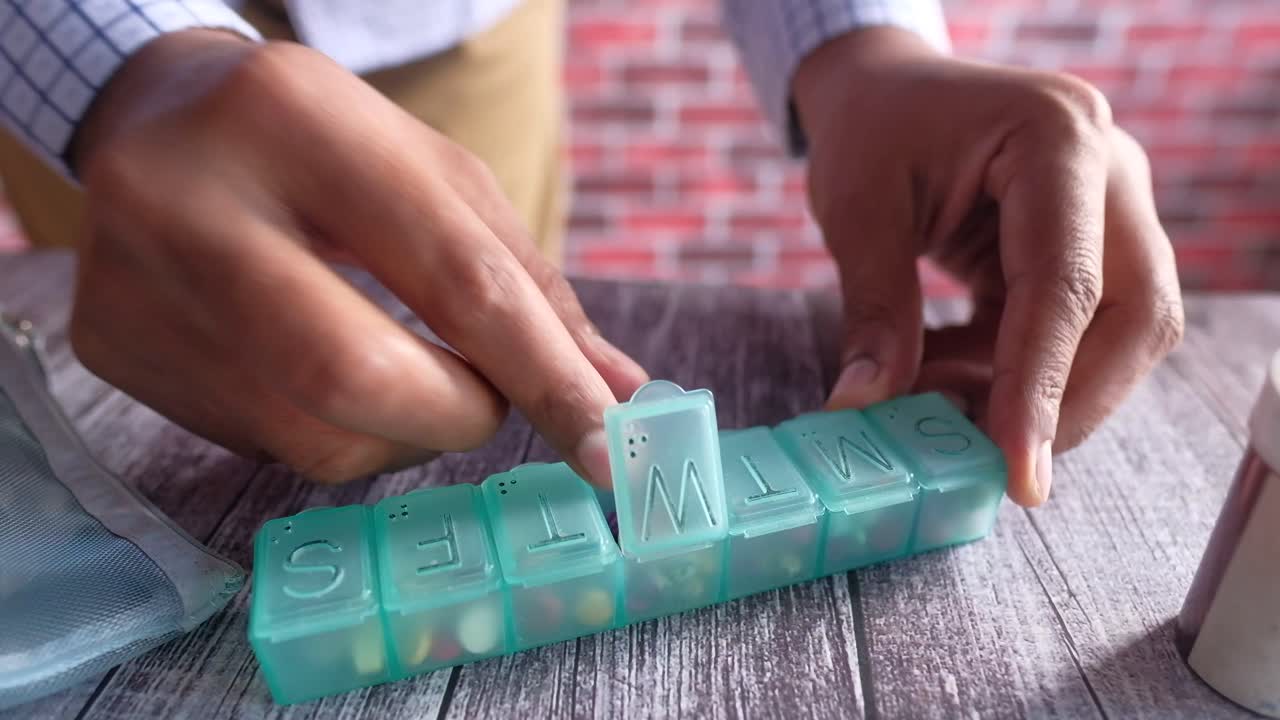 persona que utiliza un organizador de pastillas semanal