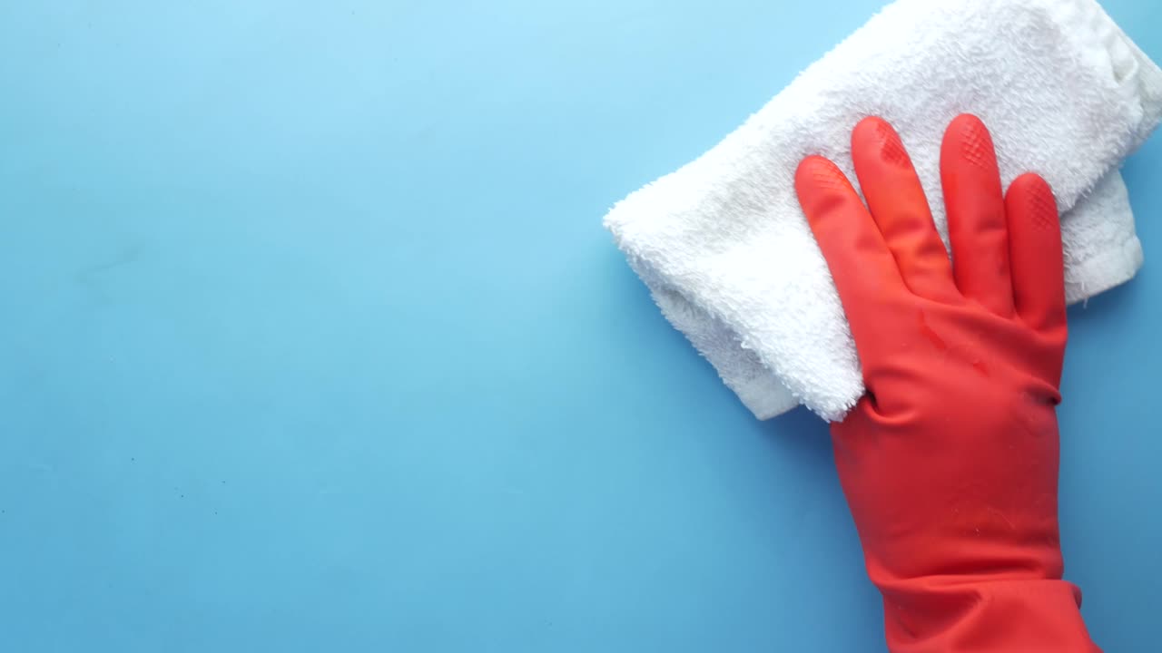limpieza con un paño blanco y guantes naranjas