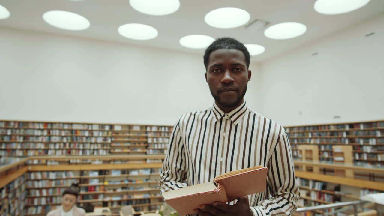 retrato de un hombre negro leyendo un libro en la biblioteca