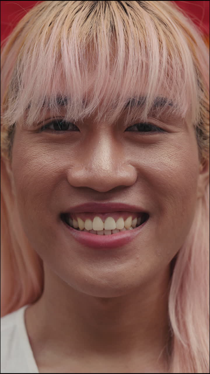 Portrait of a smiling person with pink hair