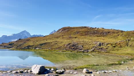 Mountain-Freedom:-Matterhorn-Mountain-Landscape-Near-Rotenboden-and-Gornergart,-Switzerland,-Europe-|-Looking-at-Travel-Couple-and-Moving-Over-Remote-Path-Near-Lake,-Hiking