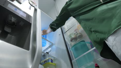 Woman-putting-a-jug-of-water-in-the-fridge-in-slow-motion