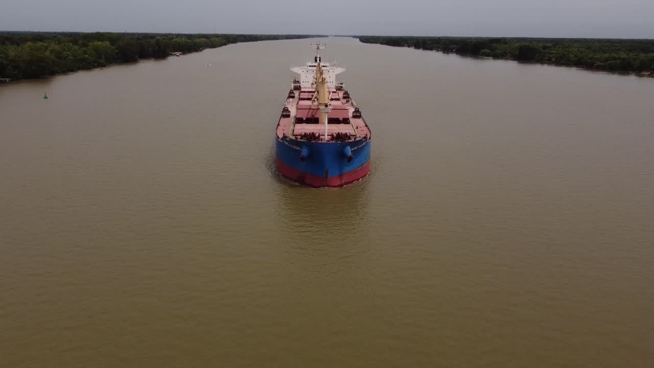toma aérea ascendente de un buque de carga de granel industrial que navega por el río parana junto a la selva tropical - inclinación hacia abajo