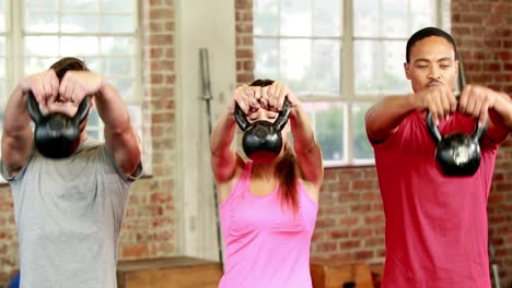 fit people lifting kettlebells together