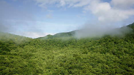 high view aerial footage of fog weaving through the smoky mountains in nc