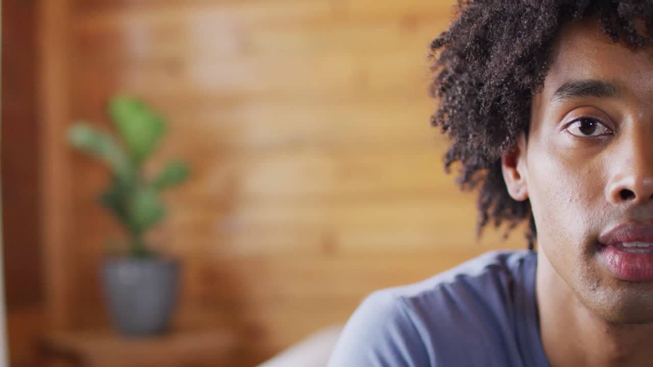 Ritratto di uomo afroamericano felice che guarda la telecamera e sorride in una baita di legno, al rallentatore