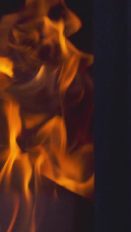 Vertical-Video-Close-Up-Flames-Fire-Logs-In-Wood-Burning-Stove-At-Home-2