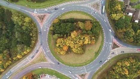 aerial view above vehicles driving around roundabout intersection urban junction