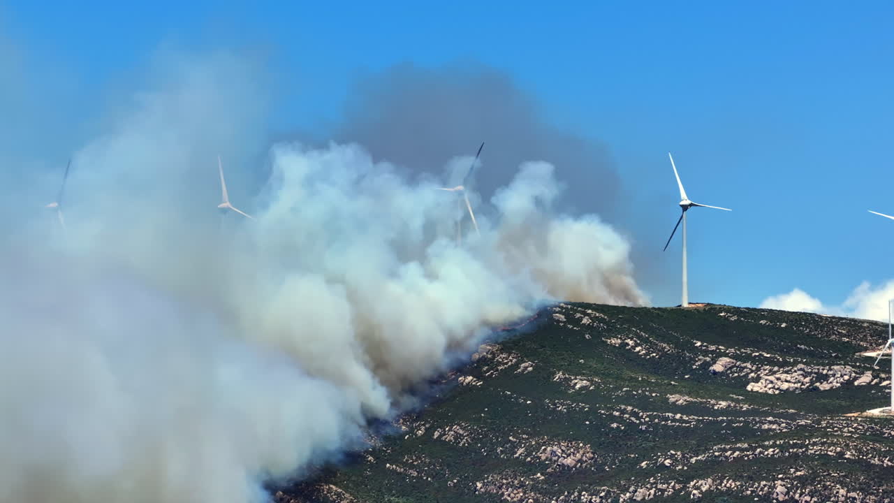 Wildfire engulfs the mountain peak of Valdevaqueros in Tarifa, Spain. Flames rage to the summit due to extreme heat and dryness, creating a dramatic and destructive scene.