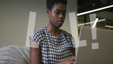 animation of lol text over african american businesswoman using laptop