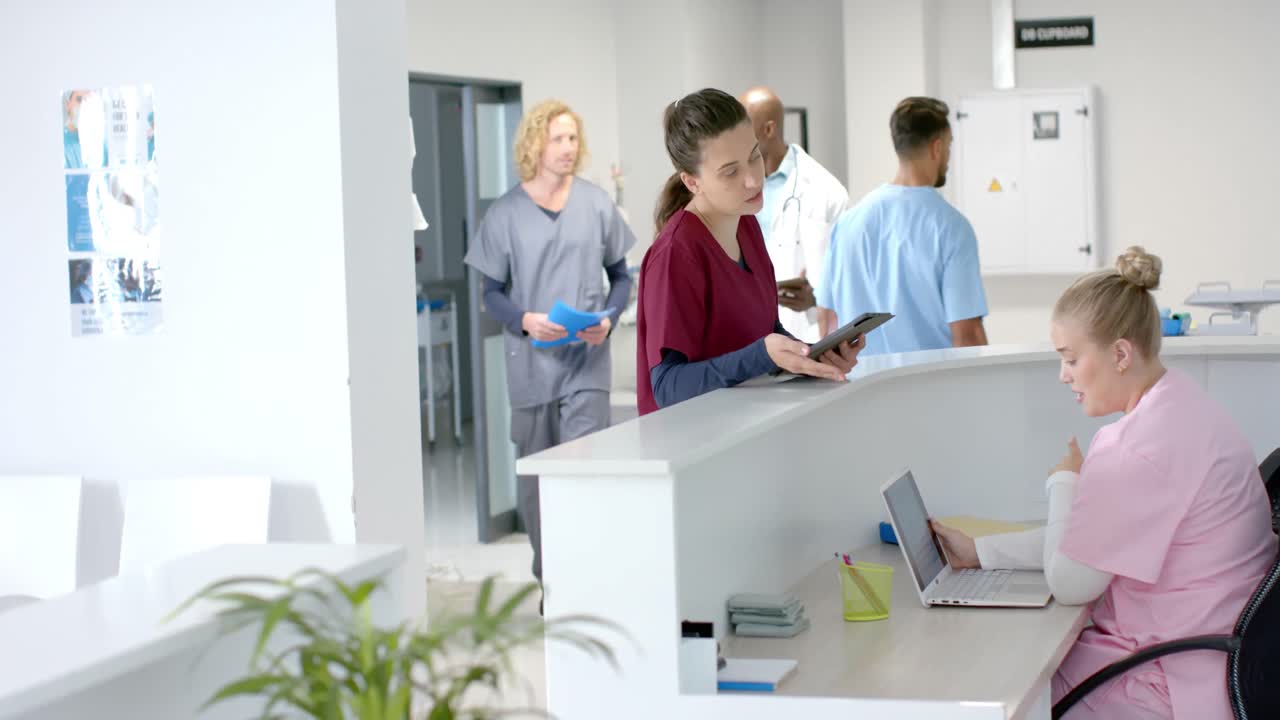 Mångkulturella läkare som pratar med medicinsk receptionist vid receptionen på sjukhuset, i slowmotion