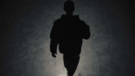 silhouette of a person walking in the dark