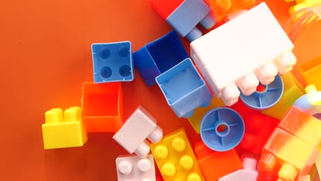 colorful plastic building blocks on an orange surface