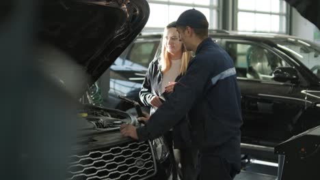 female manager discussing vehicle repair with mechanic in auto repair shop