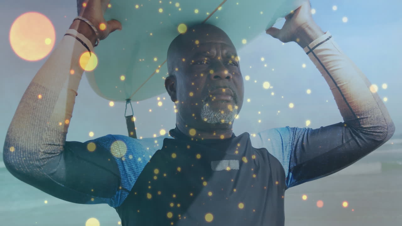 Male surfer lifting surfboard on beach, showing travel concept with golden bokeh lights